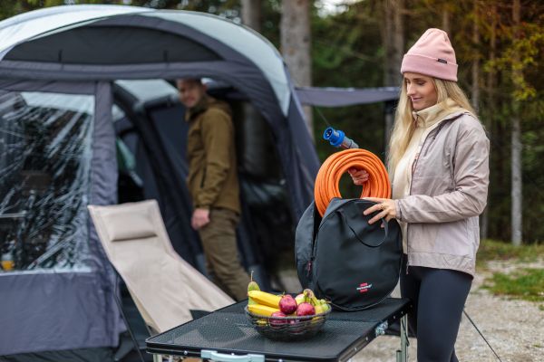 Eine Frau nimmt das Camping CEE Verl&auml;ngerungskabel aus der Aufbewahrungstasche
